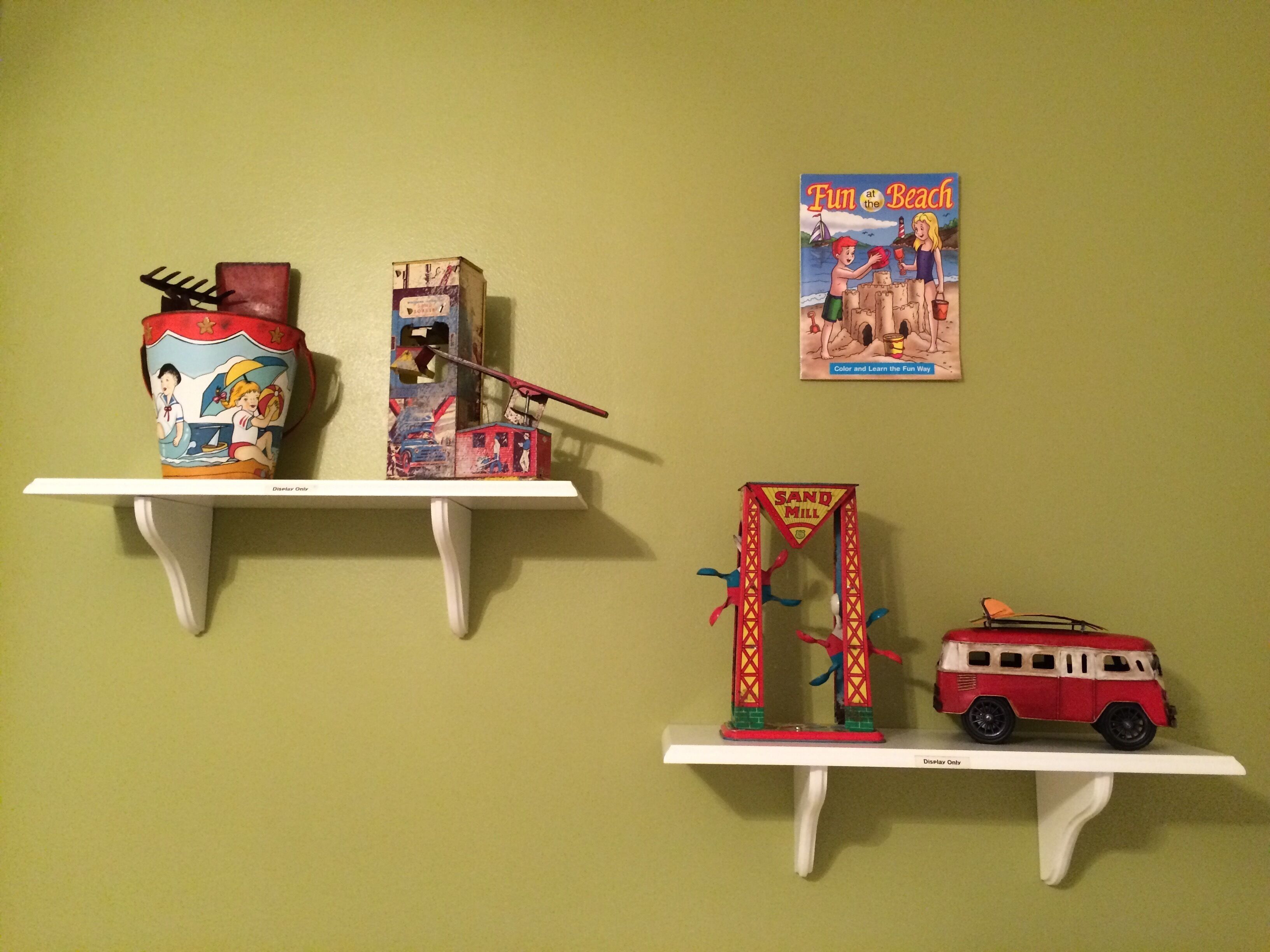 A wall with three shelves displaying various items.