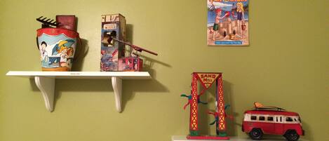A wall with three shelves displaying various items.