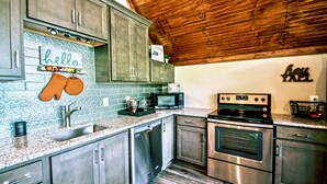 Una cocina con electrodomésticos de acero inoxidable, lavavajillas y microondas.