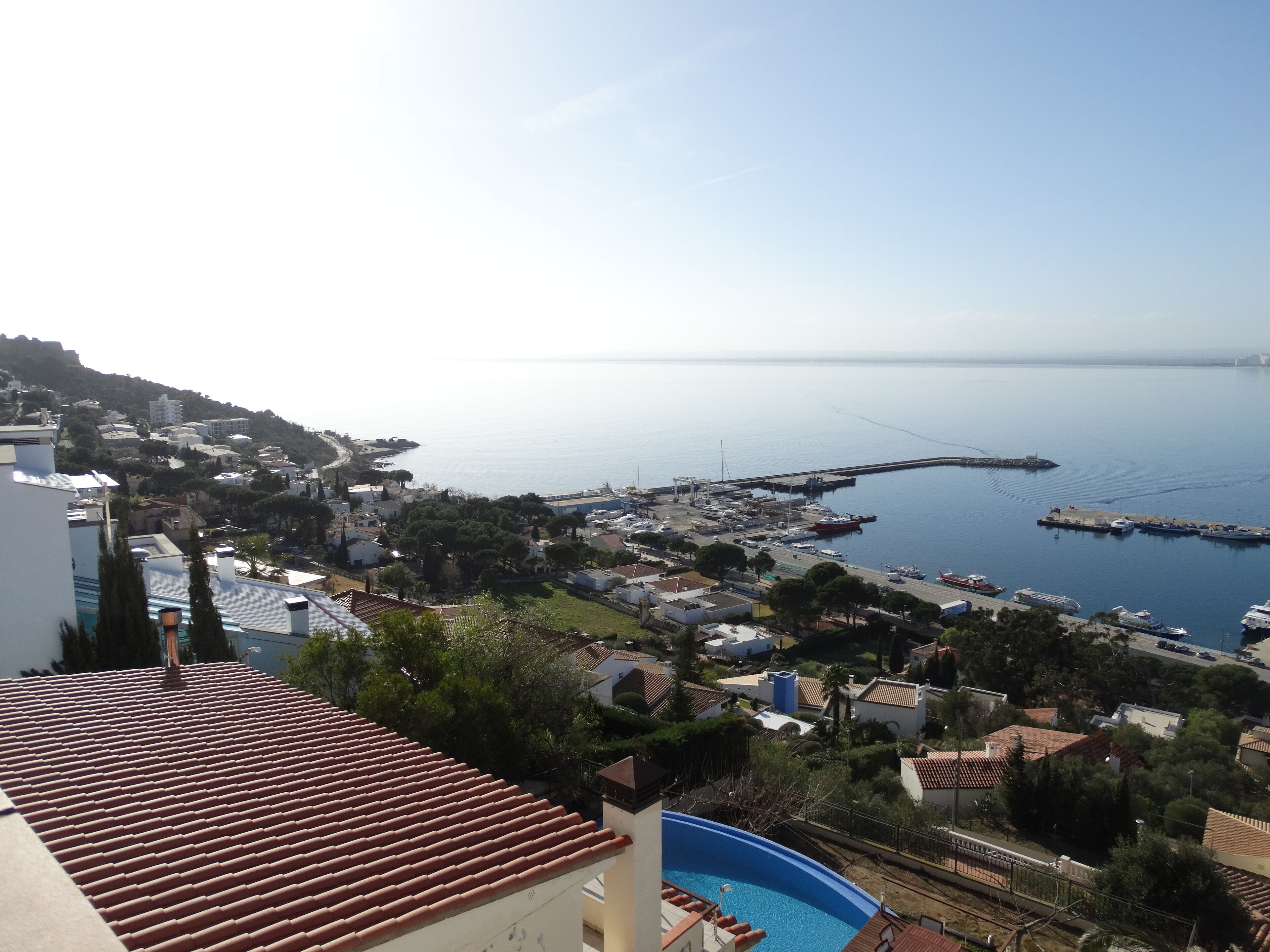 Une ville côtière dotée d’un port de plaisance, d’immeubles résidentiels et d’une piscine.