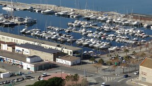 A marina with numerous boats docked, a road with vehicles, and buildings in the foreground. - Magnificent house in Roses with pool and tennis. In Puigrom area of ​​Roses (Roses)
