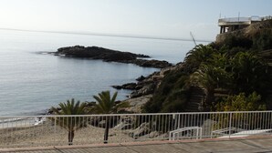 A coastal view with a rocky shoreline, a sandy beach, and a building with a balcony overlooking the sea. - Magnificent house in Roses with pool and tennis. In Puigrom area of ​​Roses (Roses)