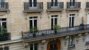 Un edificio a più piani con uno stile architettonico classico, caratterizzato da finestre e balconi regolarmente distanziati e ringhiere in ferro battuto.