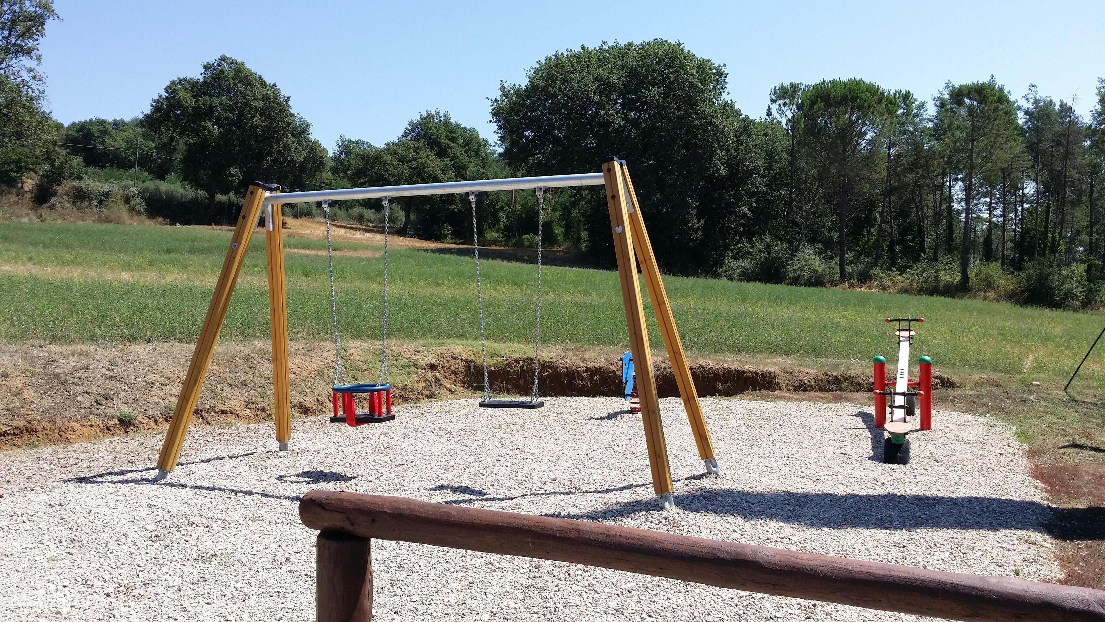 A playground with swings and a climbing structure.
