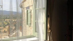 Una habitación con un ventanal grande, una escalera de madera y vistas a un paisaje montañoso.