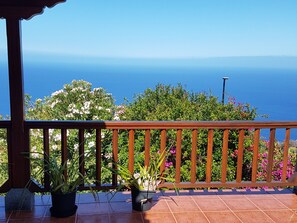 Un balcón con baranda de madera que ofrece una vista panorámica del mar.
