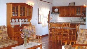 A cozy living room with wooden furniture, a dining area, and a kitchen with wooden cabinets.