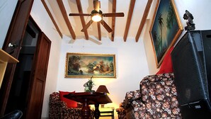 A room with a ceiling fan, a painting, a floral sofa, a table with a lamp, and a television. - TOWN HOUSE SÓLLER CENTER - ETV13701 (soller)