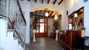 A hallway with a stone floor, wooden staircase, and a wooden cabinet with a mirror. - TOWN HOUSE SÓLLER CENTER - ETV13701 (soller)