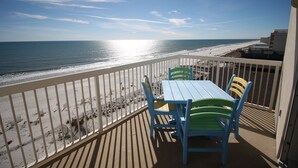 A balcony with a view of the beach and ocean.