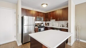 A modern kitchen with wooden cabinets, stainless steel appliances, and a large island.