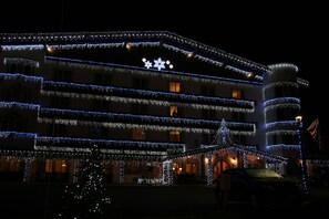 Un bâtiment à étages, décoré de guirlandes lumineuses et d’ornements en forme d’étoiles.