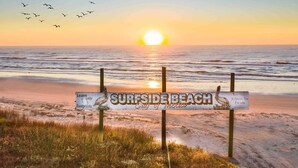 Segnale sulla spiaggia con la scritta 'SURFSIDE BEACH' e 'Golfo del Messico'.