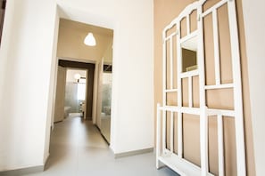 A hallway with a white door and a light fixture.
