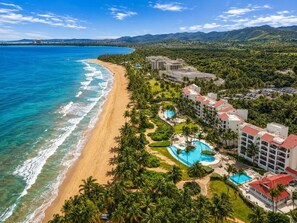 A beachfront hotel with a pool and ocean view.