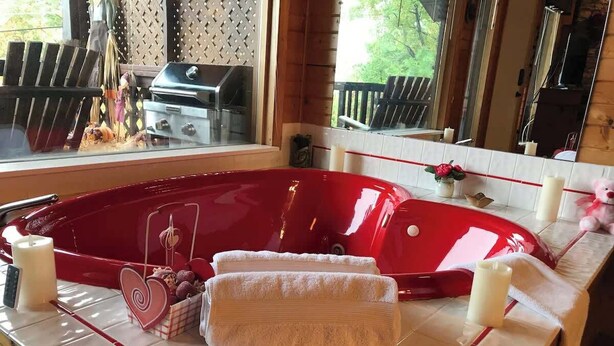 A red hot tub with towels and candles on a tiled countertop. - Honeymoon spot. Romantic. Great views. Private (Gatlinburg)