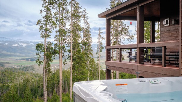 A hot tub with a wooden deck and a view of a mountainous landscape. - Epic Views! Luxe Cabin near RMNP, Trails & Fishing, and #1 Ski Resort in US (Tabernash)