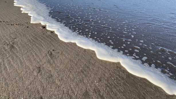 Een strand met golven die zachtjes op de kust spoelen.