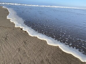 Een strand met golven die zachtjes op de kust spoelen.