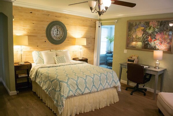 A bedroom with a bed, bedside tables, a desk, and a chair.