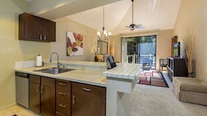 A modern kitchen with a central island, built-in cabinetry, and a dining area with a view.