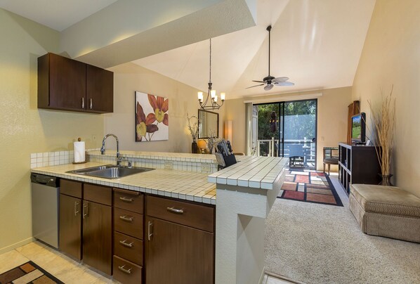 A modern kitchen with a central island, built-in cabinetry, and a dining area with a view.