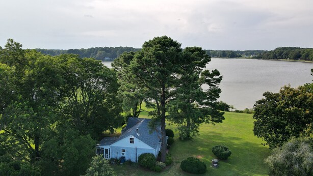 A house with a large lawn and a view of a lake.