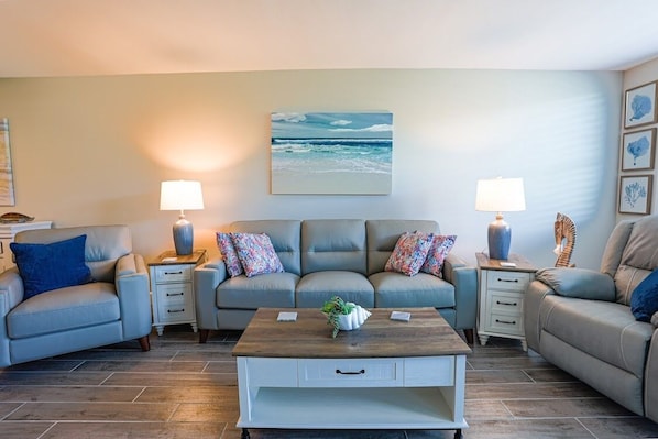 Relax in this stylish living room with a sofa, side tables, lamps, and a coffee table.