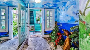 A room with a blue ceiling, a staircase, and a door leading to a balcony. - Pet Friendly, Oceanfront Downstairs Unit of Private Home, Pet Friendly (Fernandina Beach)