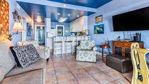A living room with a sofa, armchairs, a TV, and a ceiling fan. - Pet Friendly, Oceanfront Downstairs Unit of Private Home, Pet Friendly (Fernandina Beach)