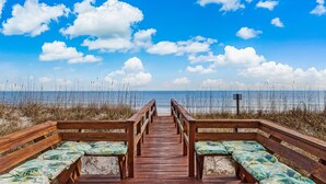 A wooden boardwalk leading to beach seating with a view of the ocean and sky. - Pet Friendly, Oceanfront Downstairs Unit of Private Home, Pet Friendly (Fernandina Beach)