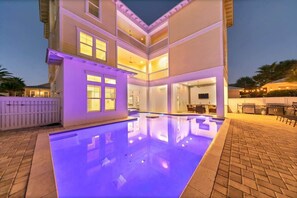 A multi-level house with a swimming pool, outdoor kitchen, and multiple balconies.