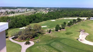 A golf course with a clear view of the fairway, sand bunkers, and surrounding trees.