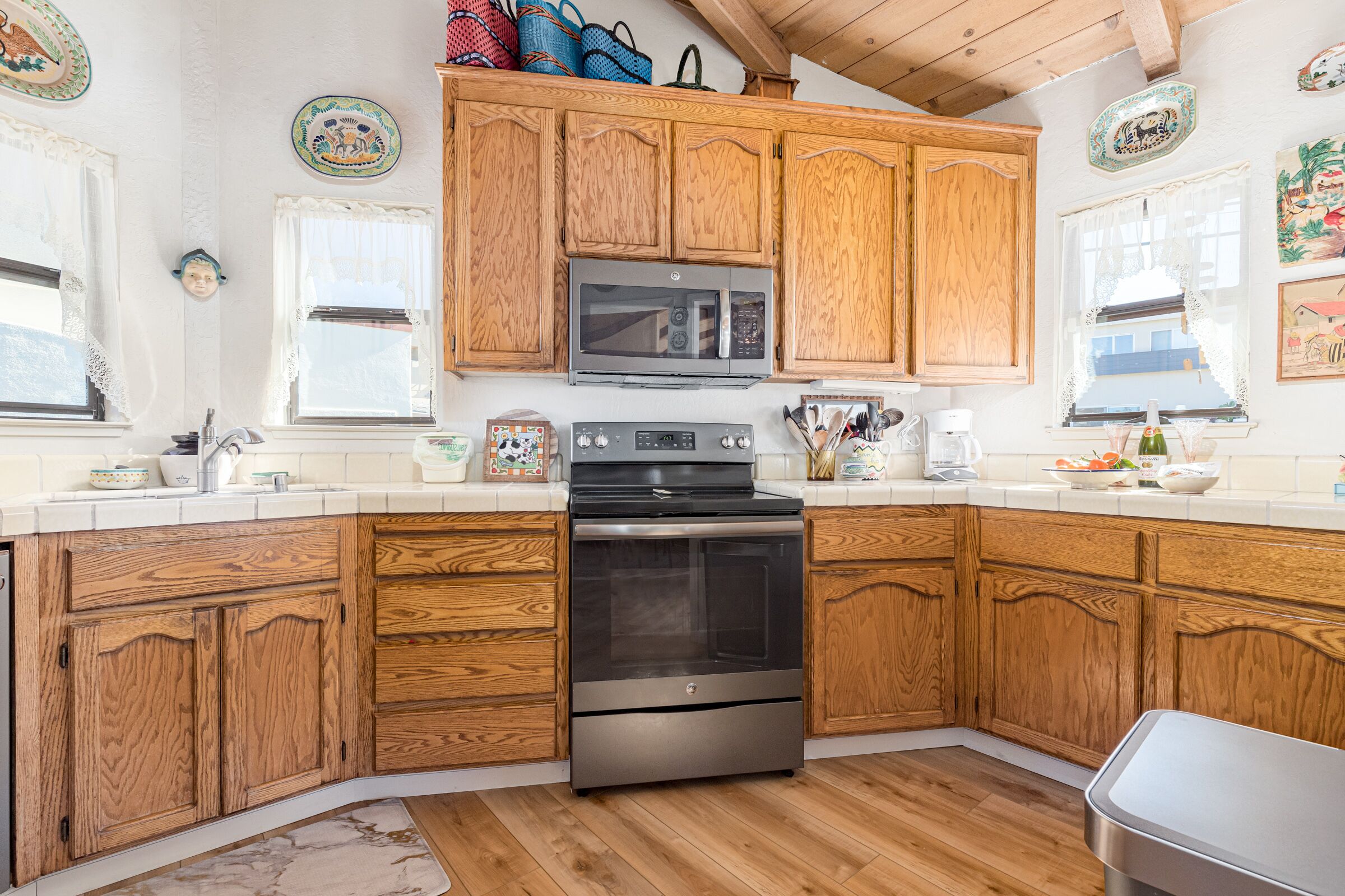 A kitchen with wooden cabinets, a stainless steel oven, and a microwave.