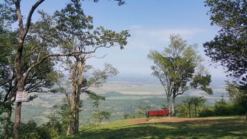 A bench overlooking a scenic landscape with a sign indicating a 5-minute rest area managed by the administration.