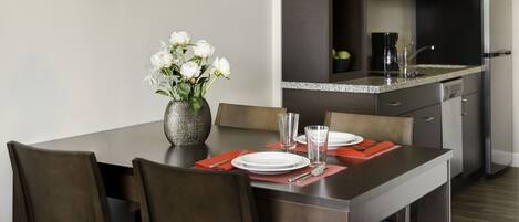 A modern kitchen with dark cabinetry, a microwave, and a refrigerator.