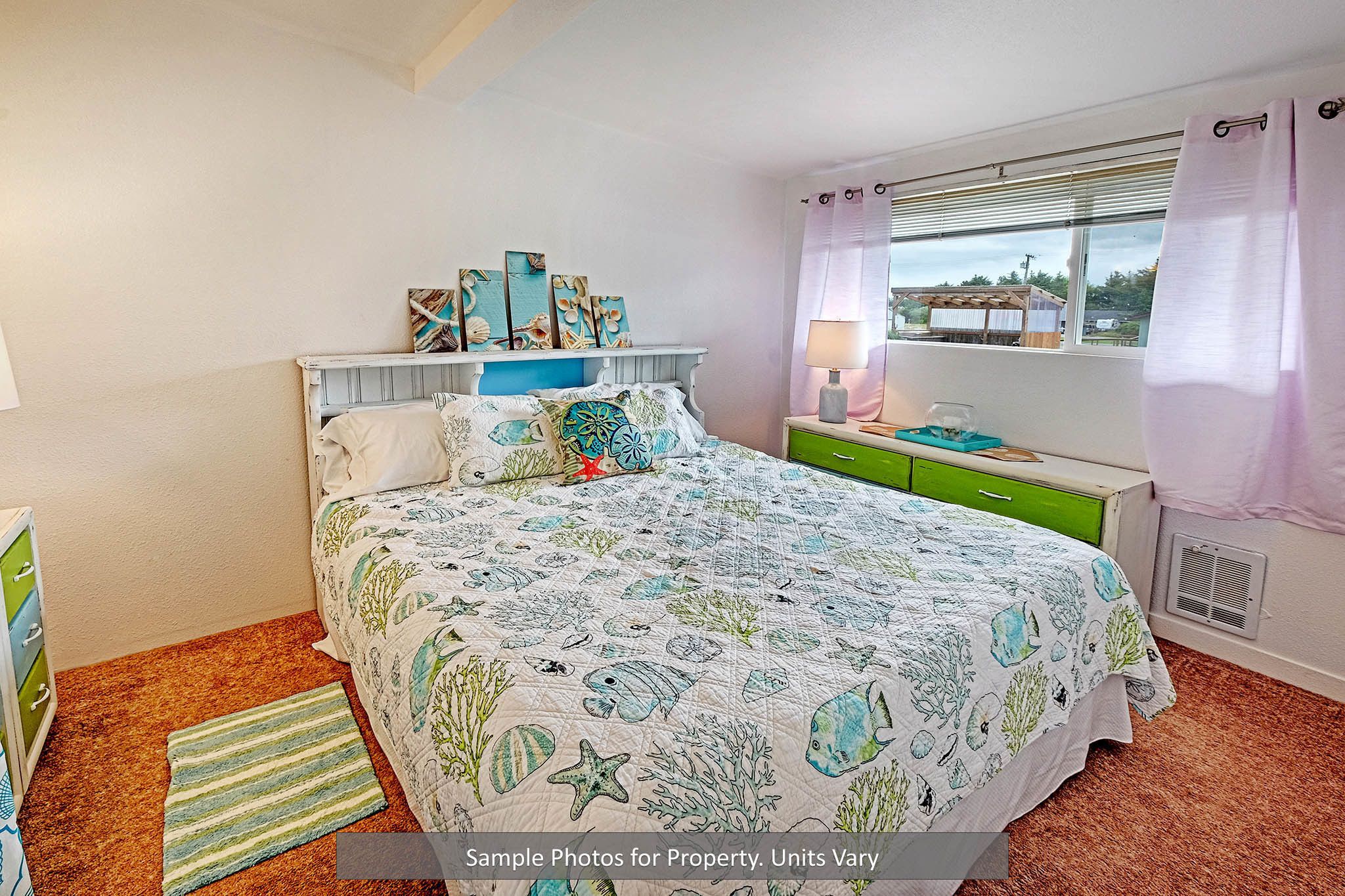 A bedroom with a bed, a nightstand, a dresser, and a window with curtains.