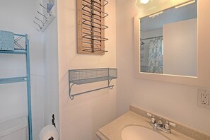 A bathroom with a sink, mirror, and towel rack. - Pacific Surf Condos (Ocean Shores)