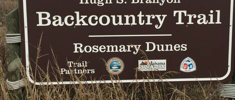 A sign for the Hugh S. Branyon Backcountry Trail in Rosemary Dunes, featuring logos of trail partners.