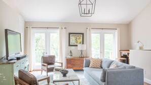 A living room with a television, sofa, chair, coffee table, and a framed picture on the wall.