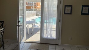Une pièce dotée d’une porte-fenêtre coulissante donnant accès à un espace piscine.