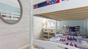 Cozy children's room with a bunk bed, circular mirror, and a dresser for a comfortable stay.