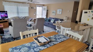 A cozy living room with a sofa, chairs, a TV, and a dining area with a table and chairs. - Charming canal front home, quiet neighborhood, one mile from ocean, Prof. Clean. (Selbyville)