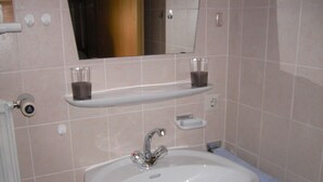 Ein Badezimmer mit Waschbecken, Spiegel und zwei Ablagen.