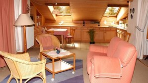 Ein gemütliches Holzinterieur mit Essbereich, einer Couch und einer Küche.