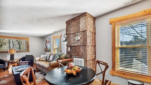 A cozy living room with a fireplace, wooden furniture, and a view of the outdoors. - Downtown Main Street "STONES" FENCED YARD (Blowing Rock)