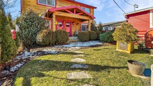 A two-story wooden house with a red roof and a covered porch. - Downtown Main Street "STONES" FENCED YARD (Blowing Rock)