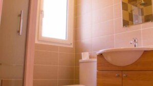 Un bagno con il water, un lavandino e uno specchio.