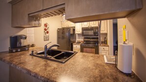 A kitchen with granite countertops, stainless steel appliances, and wooden cabinets. - Stylish/Clean 1BD/BA Pointe Royale - Close to Pool - Great Guest Reviews (Branson)