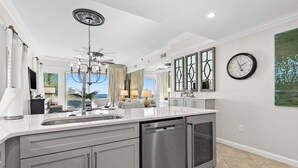 A modern kitchen with a central island, stainless steel appliances, and a view to the outside. - Beach Retreat 101 ground floor Beautiful 3 BR/3BA with Great View, Pet Friendly. (Miramar Beach)